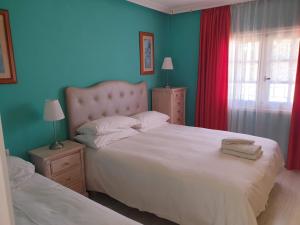 - une chambre avec 2 lits et un mur bleu dans l'établissement The Palms Golf del Sur, à San Miguel de Abona