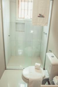 a white bathroom with a shower and a toilet at Pousada Villa Vecchia in Canela +48 photos