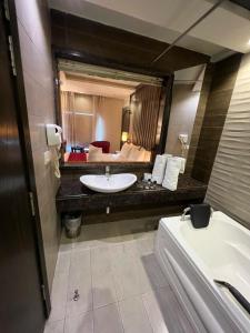 a bathroom with a sink and a large mirror at Lahore Continental Hotel in Lahore +31 photos