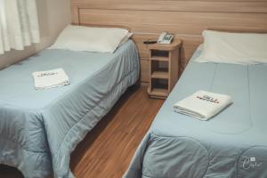 カネラにあるPousada Villa Vecchiaのベッド2台が隣同士に設置された部屋です。