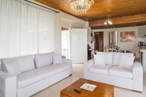a living room with two white couches and a table at Sohoro house in Fayiás