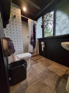 baño con aseo y lavabo y ventana en Metro Hostal Boutique en Ciudad de México