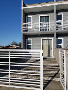una casa con una recinzione bianca davanti di S1 - Residencial Soulmar Balneário Gaivota - SC - Village Dunas Norte - 1,5 quadra do mar a Balneário Gaivotas