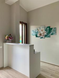 eine weiße Theke in einem Zimmer mit zwei Gemälden an der Wand in der Unterkunft il Giglio B&B in Asola