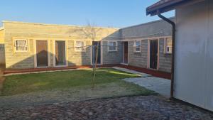 a house with a yard with a building at Moon Memories Guesthouse in Welkom