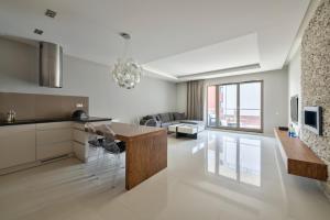 a kitchen and living room with a table and chairs at 3 City Apartments - Waterlane Valhalla in Gdańsk