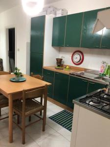a kitchen with green cabinets and a wooden table at Campodigiove Amelia in Campo di Giove