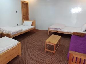 a room with three beds and a table at Tourist Guest House in Anīahgrām