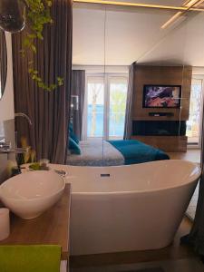 a bathroom with a tub and a sink and a bed at Apartament MoLoo III in Ostróda