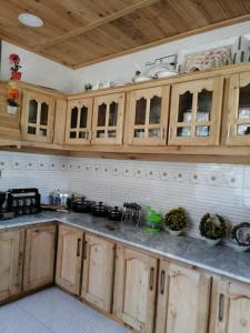 una cocina con armarios de madera y encimeras en Tourist Guest House, en Anīahgrām