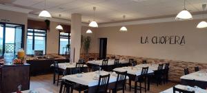 a dining room with white tables and black chairs at La Chopera in Ribadesella