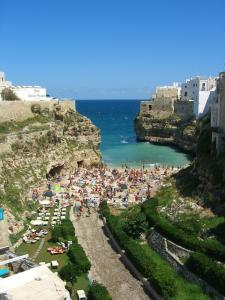 a crowd of people on a beach near the ocean at Casa Marianna Short Lets in Polignano a Mare