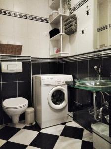 uma casa de banho com uma máquina de lavar roupa e um lavatório em Fountain View Apartment em Zagreb