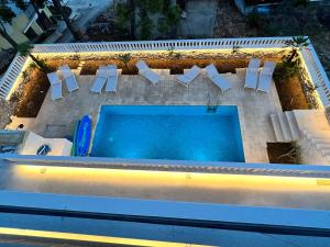 una vista sul tetto di una piscina con 2 sedie e una piscina di Luxury Beachfront Villa Carlisa a Ciovo (Bua)
