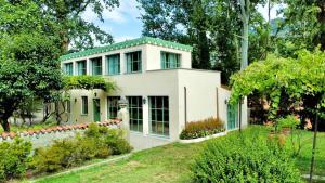 a white house with a green roof at The Greenhouse Luxury Villa on Lake Como in Como