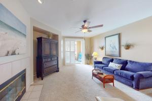 a living room with a blue couch and a fireplace at Ocean Pointe Lagoon #107 in Carlsbad