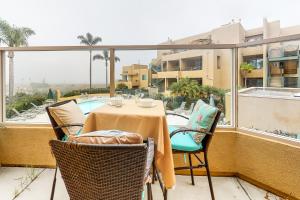 a table and chairs on a balcony with a view of a pool at Ocean Pointe Lagoon #107 in Carlsbad