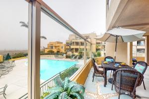 a balcony with a table and chairs and a swimming pool at Ocean Pointe Lagoon #107 in Carlsbad