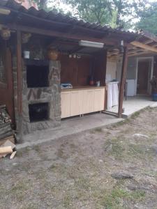 an outdoor kitchen with a stone fireplace in a house at Pescărie La Nelu in Ohaba-Sibişel +13 photos