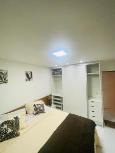 - une chambre avec un grand lit et un placard dans l'établissement Suíte Verano Stay Barra, à Rio de Janeiro