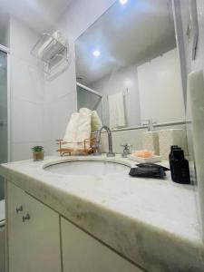 uma casa de banho com um lavatório e um espelho em Suíte Verano Stay Barra no Rio de Janeiro