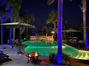 a swimming pool at night with blue lights at Modica Blu Oceano in Modica