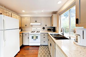 a kitchen with white appliances and a large window at Oliver Beach House in Seaside