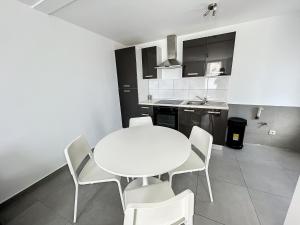 a kitchen with a white table and white chairs at Albert 18 Brussels-charleroi-airport in Charleroi