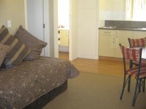 um quarto com uma cama, uma mesa e cadeiras em Shortland Court Motel em Thames