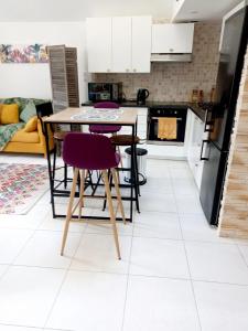 une cuisine avec une table et des chaises violettes dans l'établissement Très bel Appartement avec superbe vue sur le Port de Saint Goustan, à Auray
