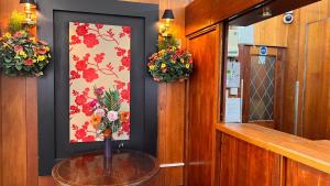 a room with a table with a picture and flowers at Gresham Hotel Bloomsbury in London