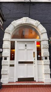 einen gewölbten Eingang zu einem Laden mit weißer Tür in der Unterkunft Gresham Hotel Bloomsbury in London
