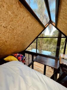 - Vistas a una habitación con cama y mesa en Toca do Pica-Pau - Tiny House em Campos com Lareira e privacidade!, en Campos do Jordão