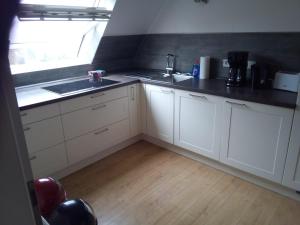 a kitchen with white cabinets and a sink and a window at Haus am Mühlenkämpchen - Schönblick in Radevormwald