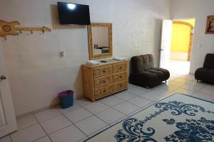 een woonkamer met een spiegel, een stoel en een dressoir bij Quinta Comala Hotel & Villas in Comala