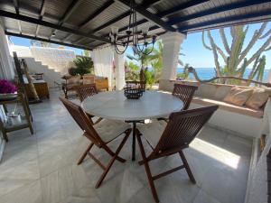ein Esszimmer mit einem Tisch, Stühlen und Meerblick in der Unterkunft Villa Playa Mojacar in Mojácar