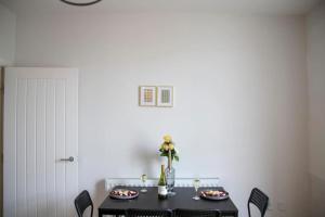 een eettafel met een zwarte tafel en stoelen bij Fortunae Cosy City Centre Apartments in Sunderland