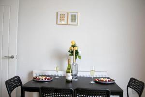 uma mesa de jantar com uma mesa preta e cadeiras em Fortunae Cosy City Centre Apartments em Sunderland