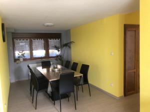 une salle à manger avec des murs jaunes, une table et des chaises dans l'établissement gîte de montagne au pied du Champ du Feu (Alsace), à Belmont