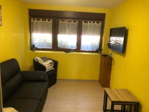 a living room with a couch and a table and windows at gîte de montagne au pied du Champ du Feu (Alsace) in Belmont