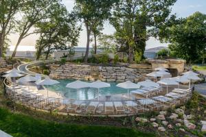 a swimming pool with umbrellas and chairs and a pool with a rock wall at Ensana Aquahouse in Saints Constantine and Helena
