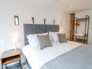a bedroom with a large white bed and a side table at Lifford Coach House in Sutton upon Trent