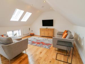 a living room with two couches and a flat screen tv at Lifford Coach House in Sutton upon Trent