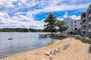 een strand met stoelen en een boom naast een waterlichaam bij WFC II Lake Access - Family or Romance - Location! in Wisconsin Dells