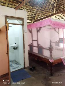 a bedroom with a bed and a sink in a room at Mida Creek Eco Camp in Watamu