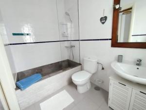 a white bathroom with a toilet and a sink at Casa Salitre in Famara