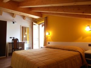 ein Schlafzimmer mit einem Bett und einer gelben Wand in der Unterkunft Chalet Kiara - Appartamenti Abar in Livigno
