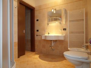 bagno con lavandino, servizi igienici e specchio di Chalet Kiara - Appartamenti Abar a Livigno