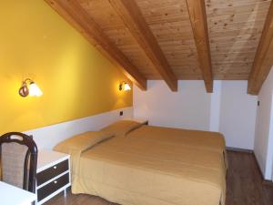 una camera con un letto e una parete gialla di Chalet Kiara - Appartamenti Abar a Livigno
