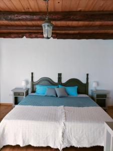 a bedroom with a large bed with blue pillows at Casa Salitre in Famara